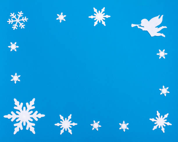 istock flat lay composition with white blank notepad, blue bell, white angel playing the trumpet and Christmas snowflakes 1289158041