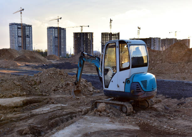 istock Mini excavator during earthmoving at construction site on sunset background. 1289158314