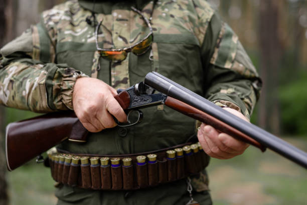 istock Old Man Hands Charging Rifle Hunting in Forest. 1289158321