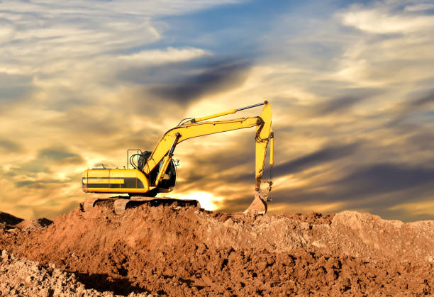istock Excavator working on earthmoving at open pit mining on amazing sunset background 1289158388