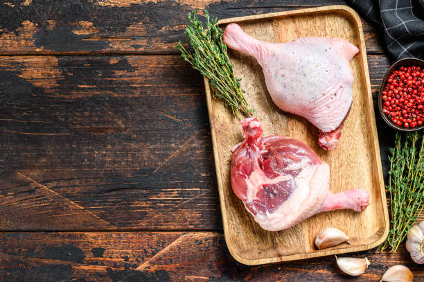 istock Raw Duck legs on a wooden tray.  Dark background. Top view. Copy space 1289158468