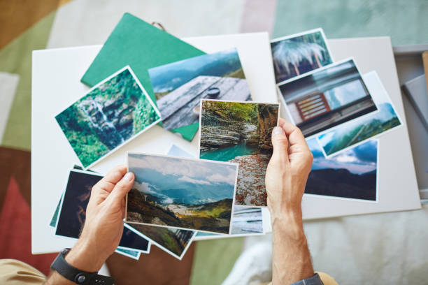 Making a map of desires Close-up of man choosing the photos for collage or making a map of desires at the table vacations photos stock pictures, royalty-free photos & images