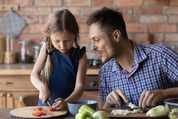 istock Caring single father teaching attentive daughter cook meals at kitchen 1289162186