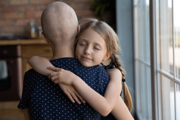 Caring daughter hugging ill mother believing in good therapy result Love can make wonders. Caring small daughter hugging tight holding in arms ill hairless mother fighting with oncology supporting comforting believing in happy future life after good result of therapy cancer illness stock pictures, royalty-free photos & images