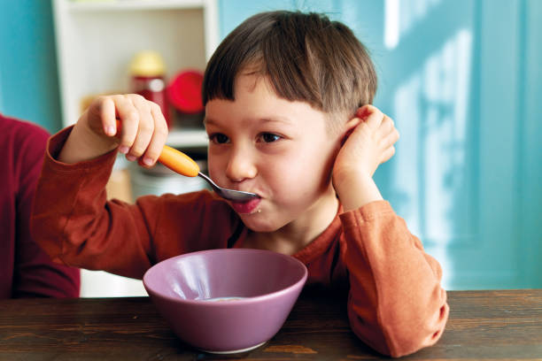 istock Cute children eating corn flakes with milk for breakfast 1289162328