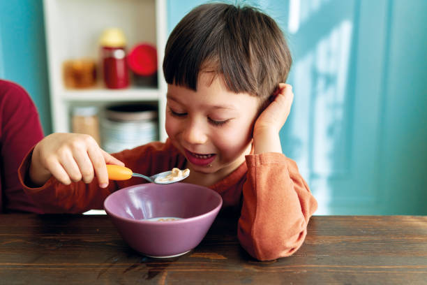 istock Cute children eating corn flakes with milk for breakfast 1289162450