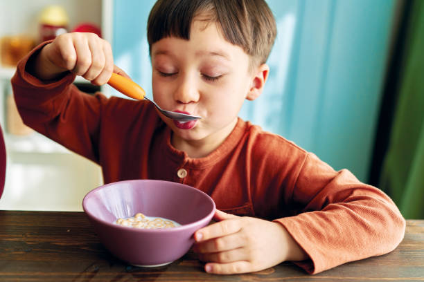 istock Cute children eating corn flakes with milk for breakfast 1289162549