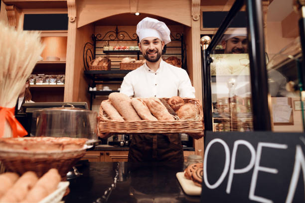 istock Young Bearded Man in Apron Standing in Bakery. 1289162591