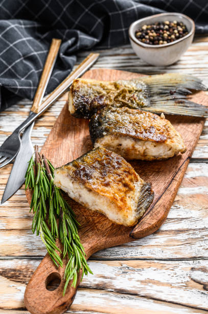 istock Grilled river fish silver carp on a cutting board. Wooden background. Top view. 1289162757