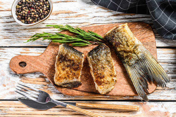 istock Grilled river fish silver carp on a cutting board. Wooden background. Top view. 1289162778
