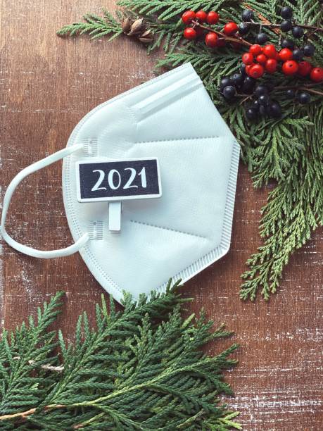 istock Rustic Christmas chalkboard with space for your text and logo. Face protective mask on brown table top view 1289164922