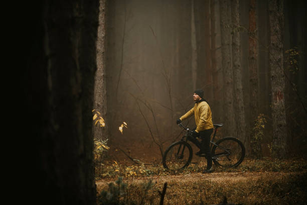 istock Young man taking a brake during biking through autumn forest 1289165086