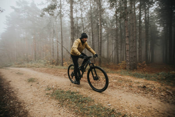 istock Young man biking through autumn forest 1289165095