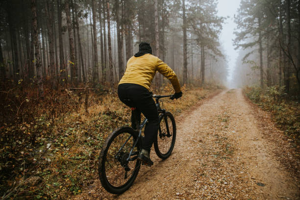 istock Young man biking through autumn forest 1289165110