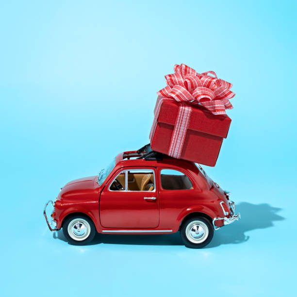 istock Christmas layout made with red car with wrapped gift box on the top 1289165222