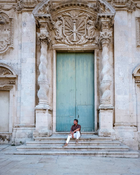 мужчины на citytrip ortigia в сиракузах в первой половине дня. путешествие фотография из сиракуз, италия на острове сицилия. собор плаза и рынок с л� - citytrip стоковые фото и изображения