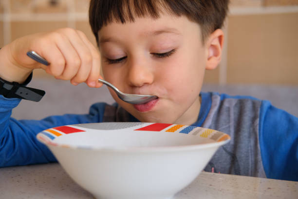 istock Cute children eating corn flakes with milk for breakfast 1289167880