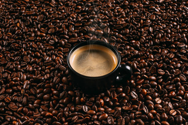 caffè espresso su chicchi di caffè freschi - coffee crop bean seed directly above foto e immagini stock