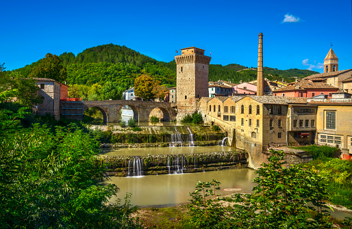 Roman bridge, medieval tower and Metauro river. Fermignano, province Pesaro and Urbino, Marche region, Italy, Europe.