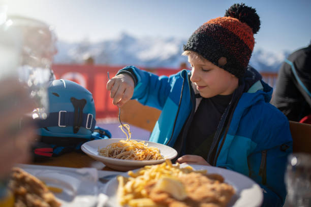 mały chłopiec jedzący lunch w alpejskiej restauracji narciarskiej - apres ski friendship skiing enjoyment zdjęcia i obrazy z banku zdjęć