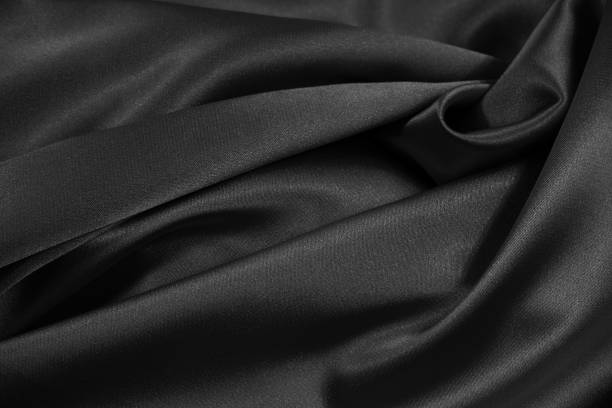 istock Black satin background. Crumpled shiny fabric texture background. Black elegant silk background. 1289172001