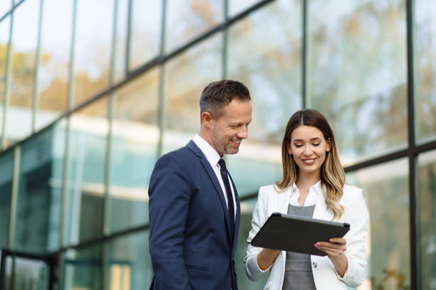 istock Two business people discussing work on tablet computer outdoors 1289172084