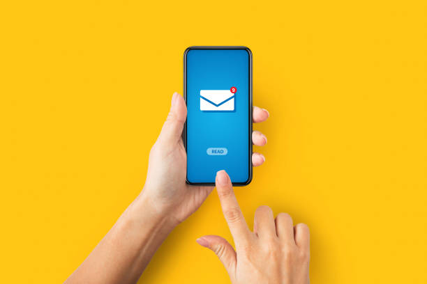 istock Online correspondence. Top view of young lady pressing READ button on cellphone with incoming email, orange background 1289176917