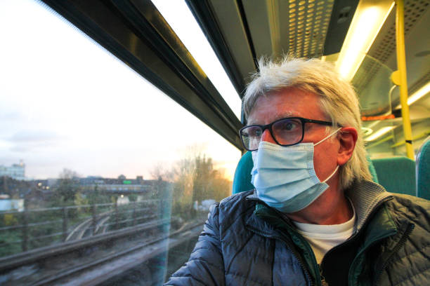 istock Senior man wearing protective face mask in train carriage 1289177015