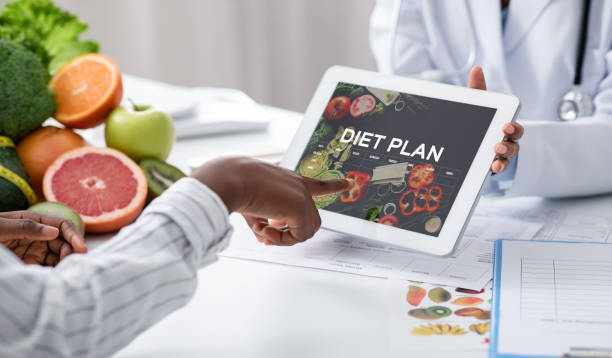 istock Dietologist Doctor Holding Digital Tablet With Diet Plan App, Patient Choosing Nutrition 1289178019