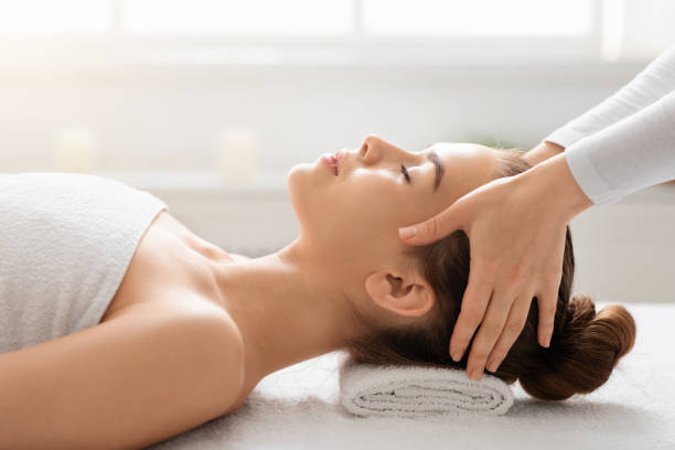 istock Masseuse making relaxing head massage for young beautiful lady 1289178077