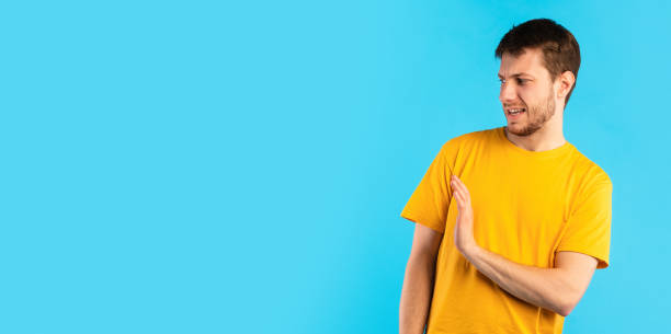 istock Shocked guy with disgusted face showing stop sign 1289178291