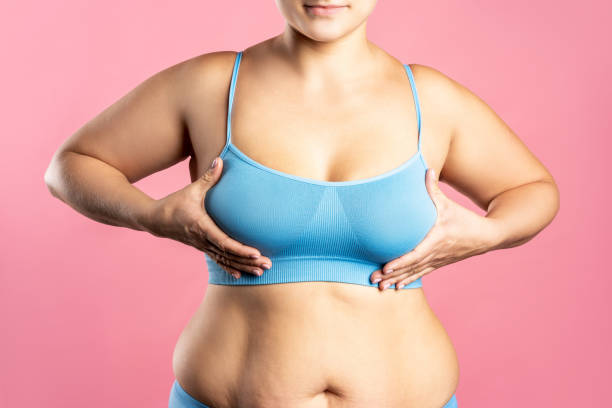 istock Big natural breasts in blue bra close-up on pink background 1289178703