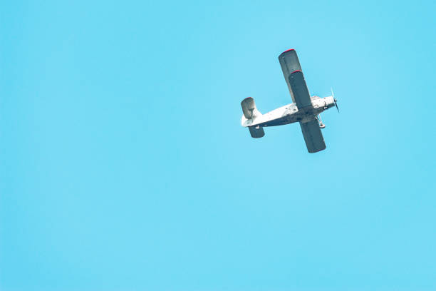 istock Old retro plane flies in the blue sky. 1289179266