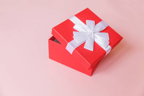 istock Christmas New Year birthday valentine celebration present romantic concept. Simply minimal design red gift box isolated on pastel pink colorful background. Flat lay top view, copy space 1289179727