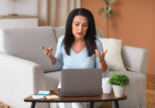 istock Serious woman sitting on couch, having video call on computer 1289179989