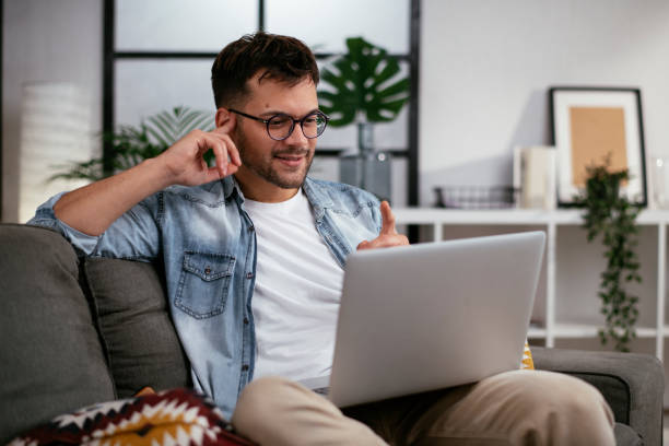 istock Man sitting in the living room and using the laptop. 1289180599