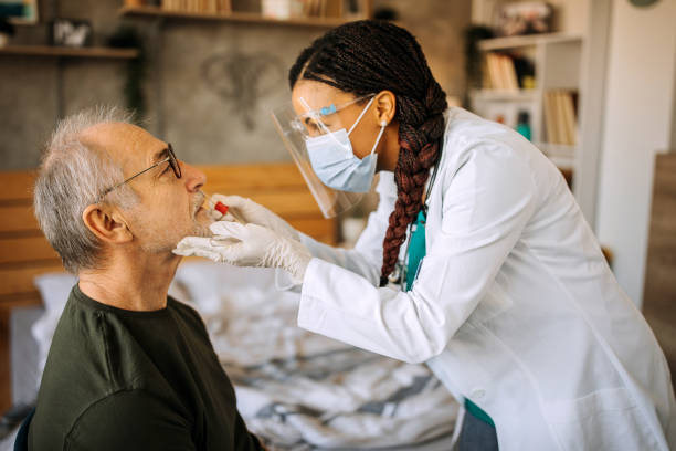 istock Nurse taking swab test from senior man patient during home visit 1289183367