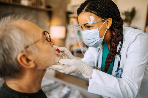 istock Nurse taking swab test from senior man patient during home visit 1289183414