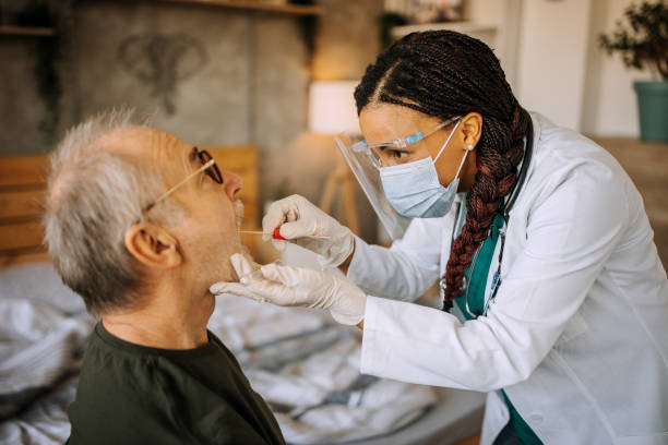 istock Nurse taking swab test from senior man patient during home visit 1289183909