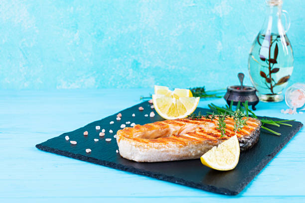 istock Grilled salmon fish on stone board. Salt atlantic salmon fried on grill with lemon 1289186351