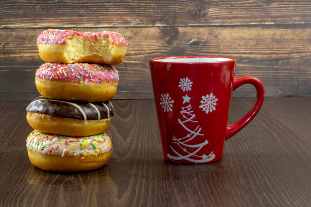 istock Fresh donuts stacked stack and cup of coffee on dark wooden background close up 1289186459
