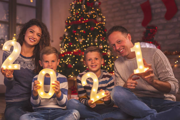 istock Mother, father and two boys holding illuminated numbers 2021 1289191152