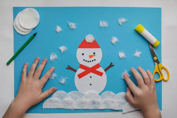 Photo of Easy Winter Crafts for kids. little child creative Snowman from paper and cotton disc. Children's art project. DIY concept. Handmade Easy Paper Crafts For Kids