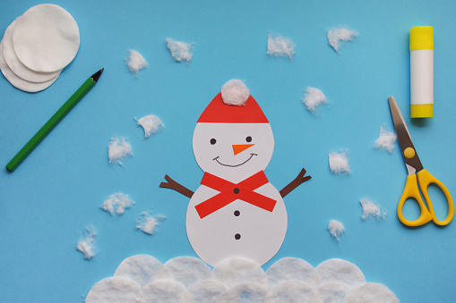 Easy Winter Crafts for kids. little child creative Snowman from paper and cotton disc. Children's art project. DIY concept. Handmade Easy Paper Crafts For Kids