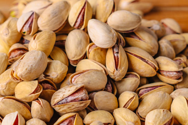 istock Green fresh pistachios as texture on wooden background 1289191992