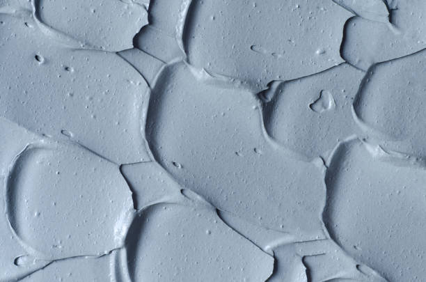 istock Gray bentonite facial clay (mask, face cream, body wrap) texture close up, selective focus. Abstract background with brush strokes. 1289192806