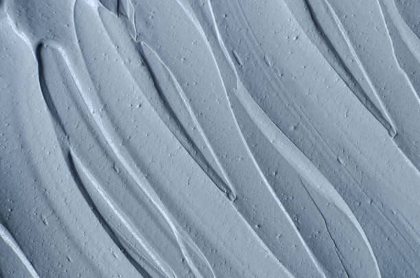 istock Gray bentonite facial clay (mask, face cream, body wrap) texture close up, selective focus. Abstract background with brush strokes. 1289192983