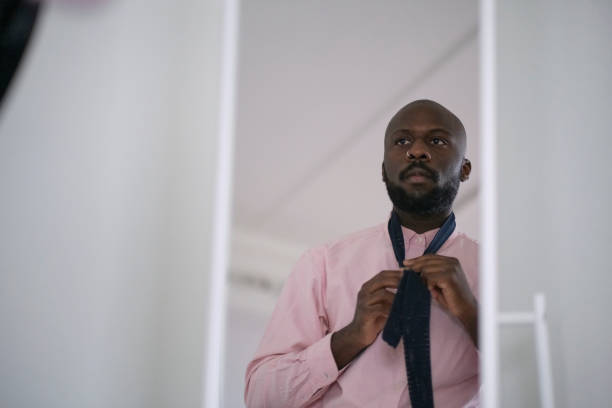 아프리카계 미국인 남자 에 셔츠 드레싱 과 조정 넥타이 에 목 에 집에서 - necktie pink shirt luxury 뉴스 사진 이미지