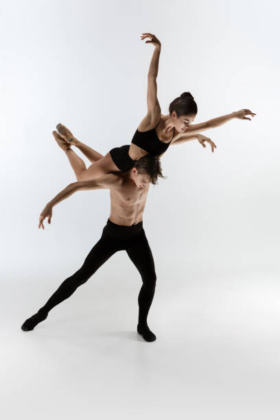 istock Young and graceful ballet dancers in minimal black style isolated on white studio background 1289198163