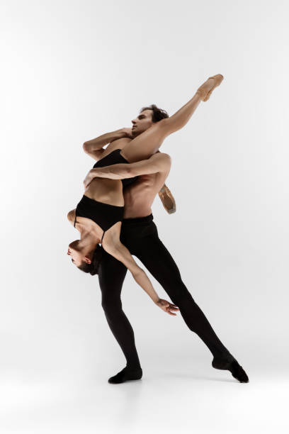istock Young and graceful ballet dancers in minimal black style isolated on white studio background 1289198172